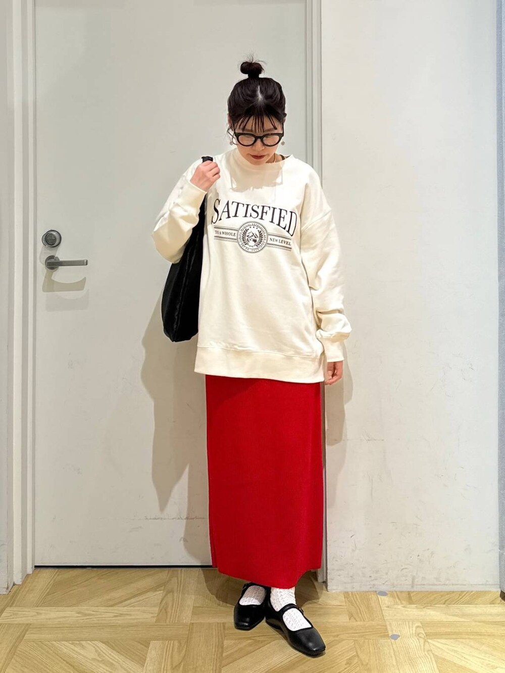 レッド系のスカート、ホワイト系のスウェット、ブラック系のバレエシューズを着用したレディースの春コーディネートの4枚目の写真