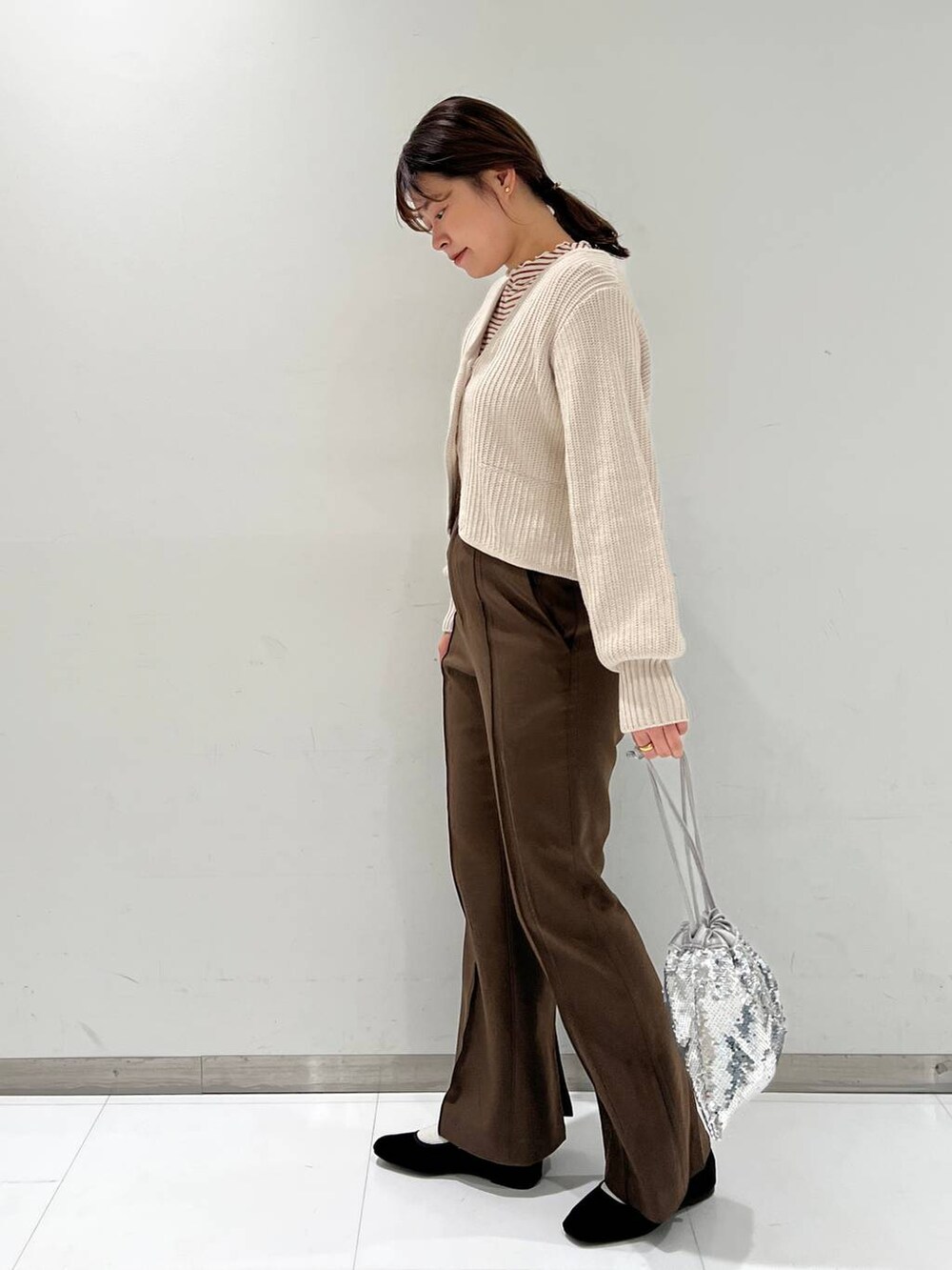 ブラウン系のTシャツ/カットソー、その他のパンプス、シルバー系のハンドバッグを着用したレディースの秋コーディネートの3枚目の写真