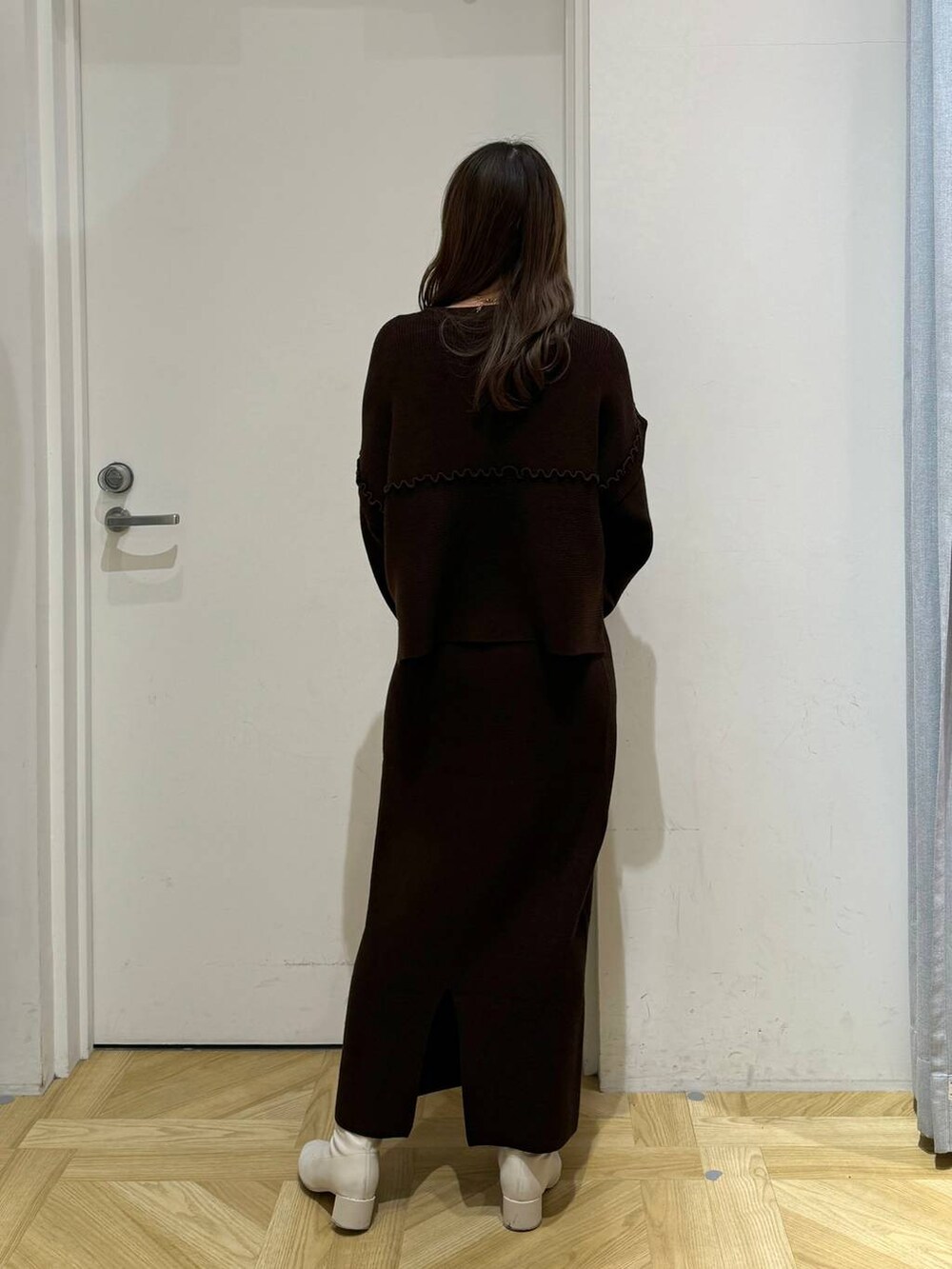 ホワイト系のブーツ、ブラウン系のショルダーバッグ、ブラウン系のワンピースを着用したレディースの冬コーディネートの8枚目の写真