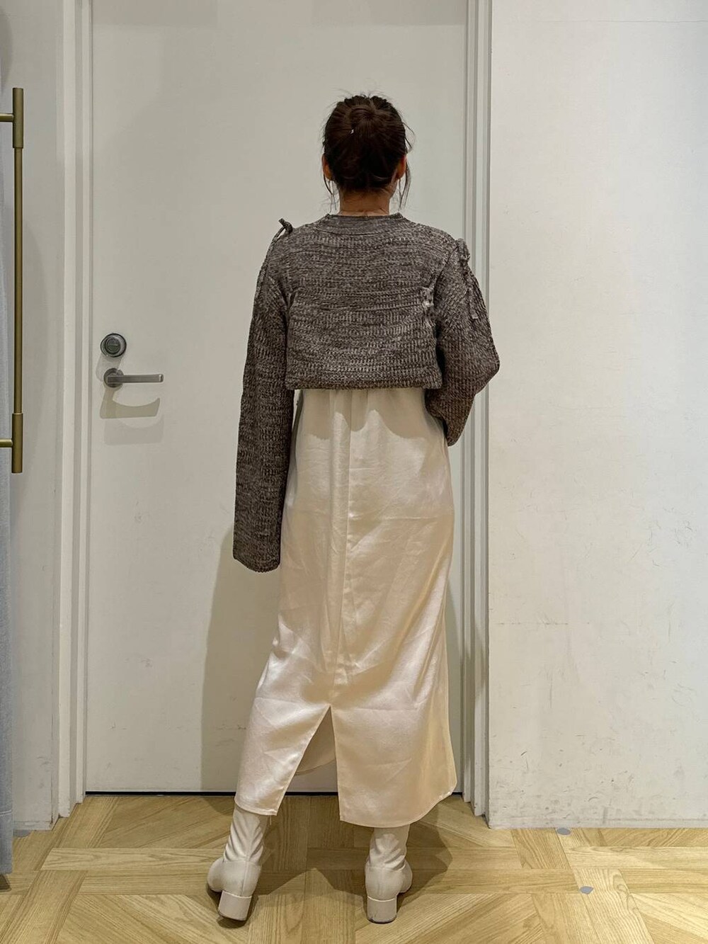 ホワイト系のその他アウター、ホワイト系のブーツ、ブラウン系のワンピースを着用したレディースの冬コーディネートの7枚目の写真