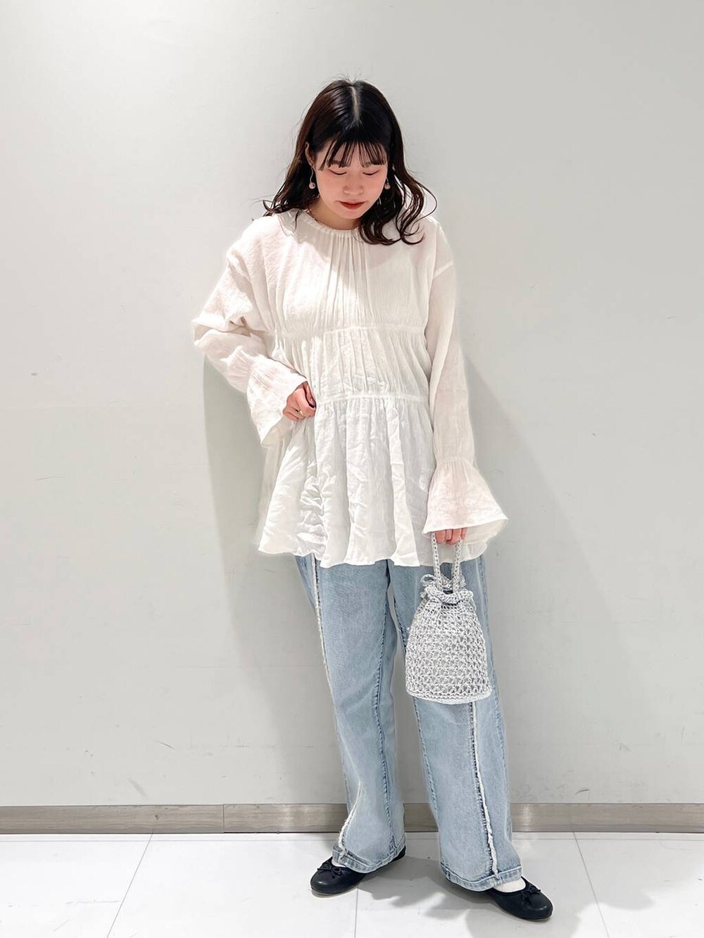 ホワイト系のシャツ/ブラウス、ブラック系のバレエシューズ、ブルー系のデニムパンツを着用したレディースの春コーディネートの2枚目の写真