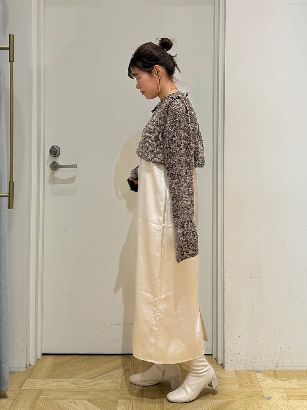 ホワイト系のその他アウター、ホワイト系のブーツ、ブラウン系のワンピースを着用したレディースの冬コーディネートの6枚目の写真