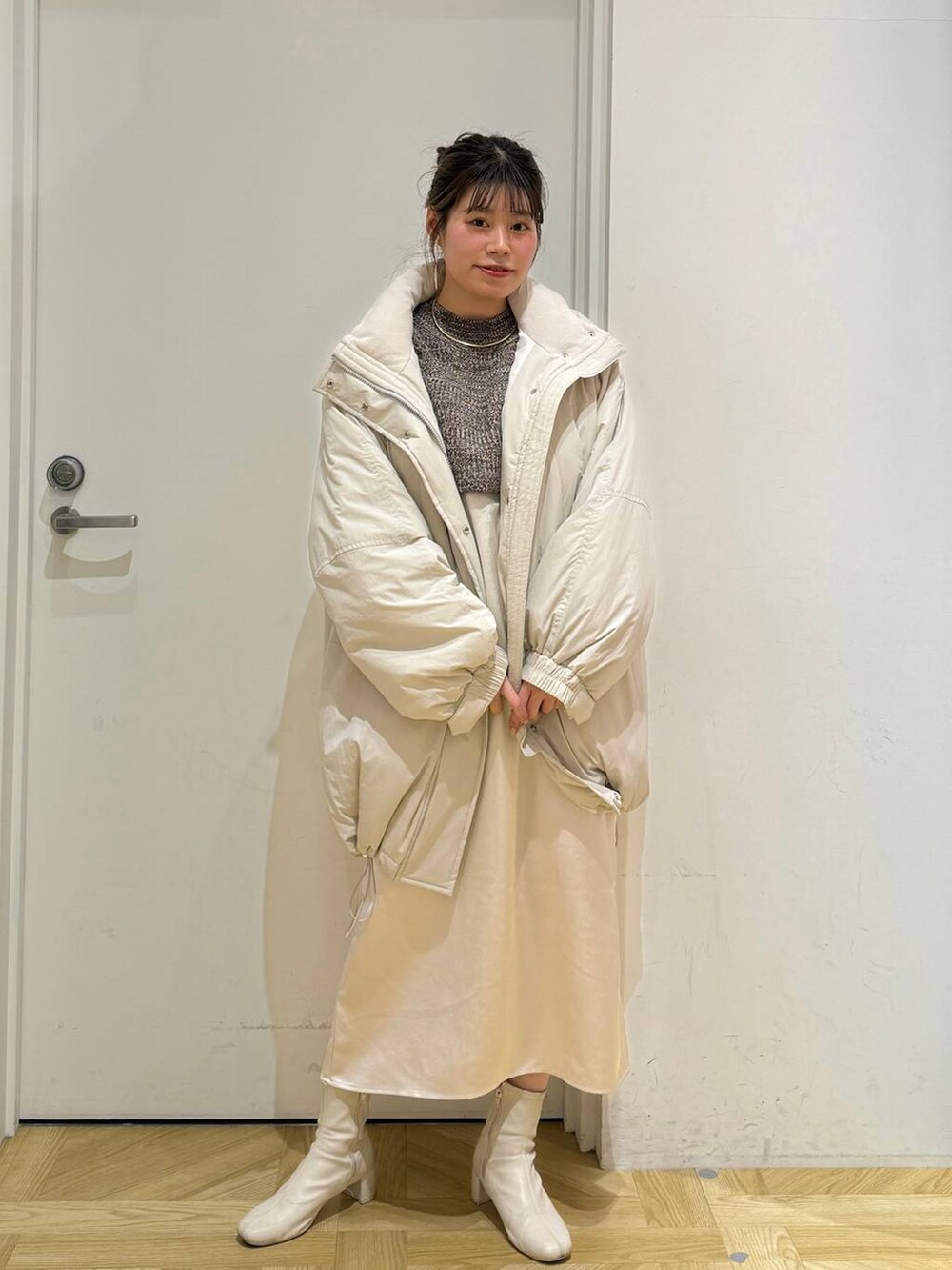 ホワイト系のその他アウター、ホワイト系のブーツ、ブラウン系のワンピースを着用したレディースの冬コーディネートの2枚目の写真