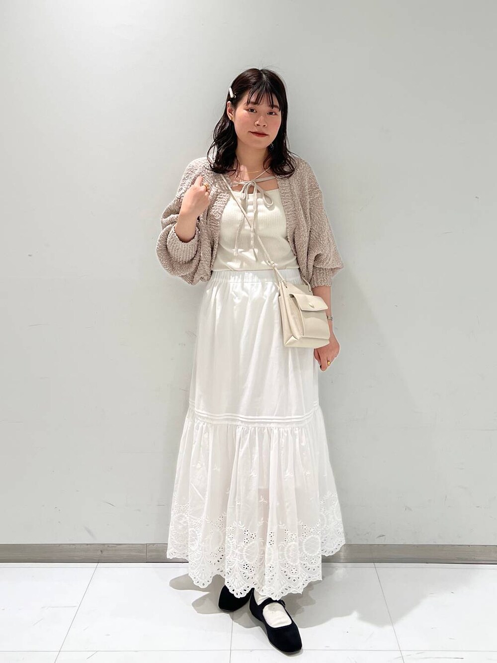 ホワイト系のスカート、ホワイト系のショルダーバッグ、その他のパンプスを着用したレディースの冬コーディネートの2枚目の写真