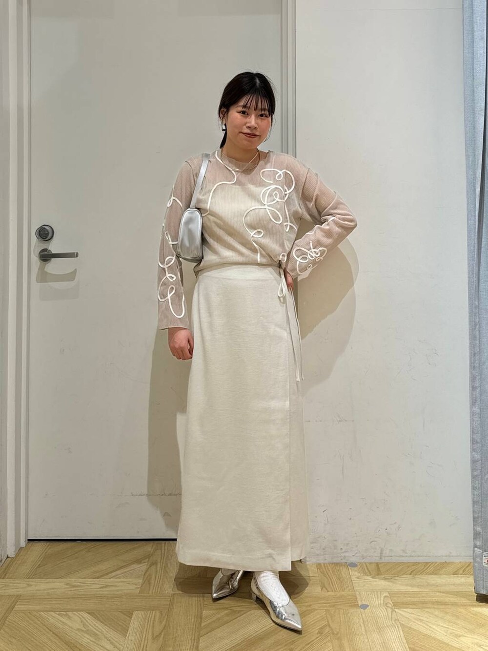 ホワイト系のスカート、ホワイト系のテーラードジャケット、シルバー系のトートバッグを着用したレディースの春コーディネートの7枚目の写真