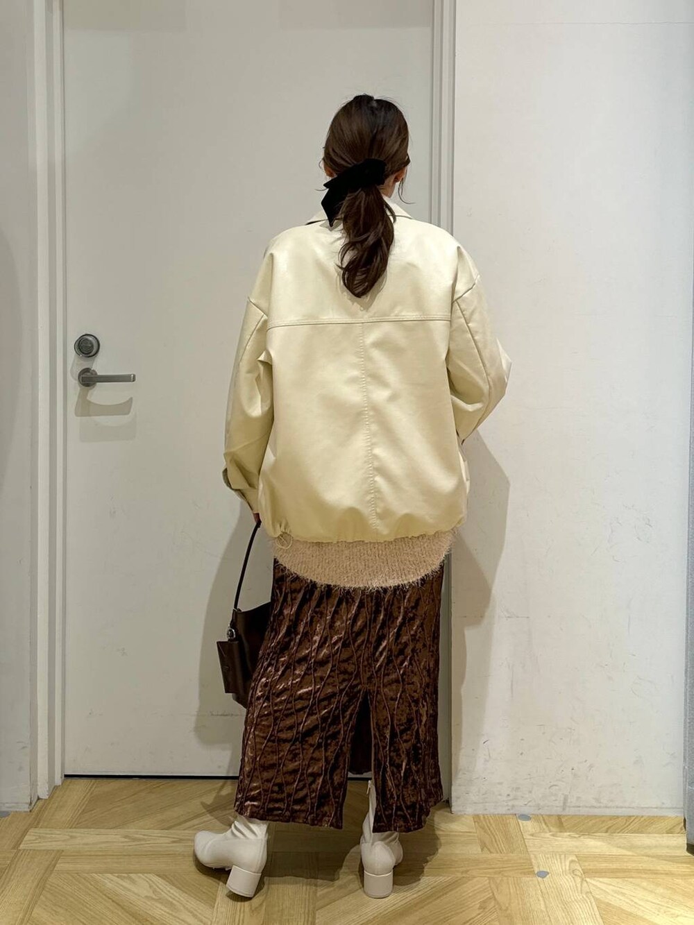 ホワイト系のニット/セーター、ホワイト系のブーツ、ブラウン系のワンピースを着用したレディースの冬コーディネートの3枚目の写真