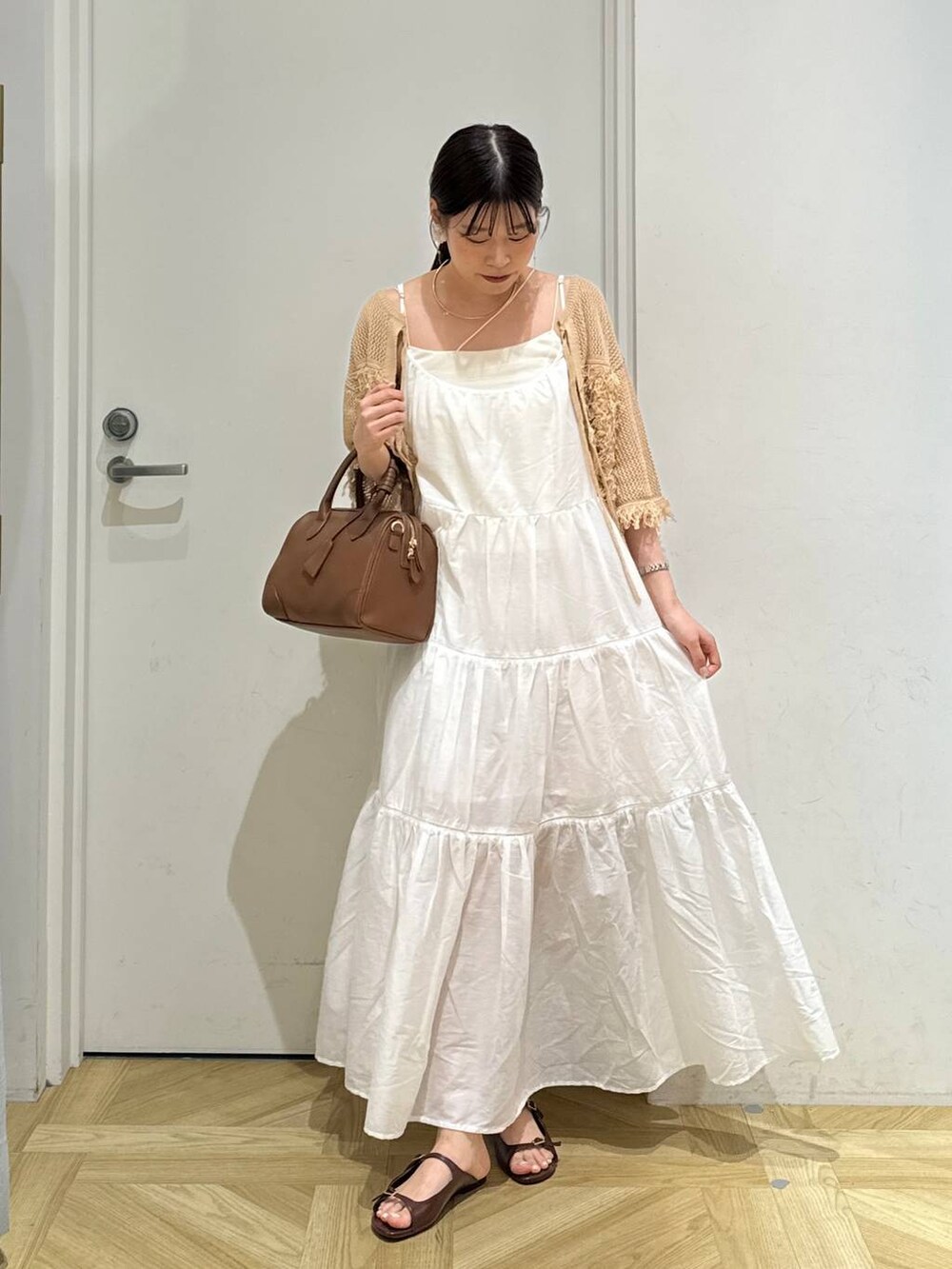 ホワイト系のワンピース、ブラウン系のサンダル、ブラウン系のショルダーバッグを着用したレディースの夏コーディネートの3枚目の写真