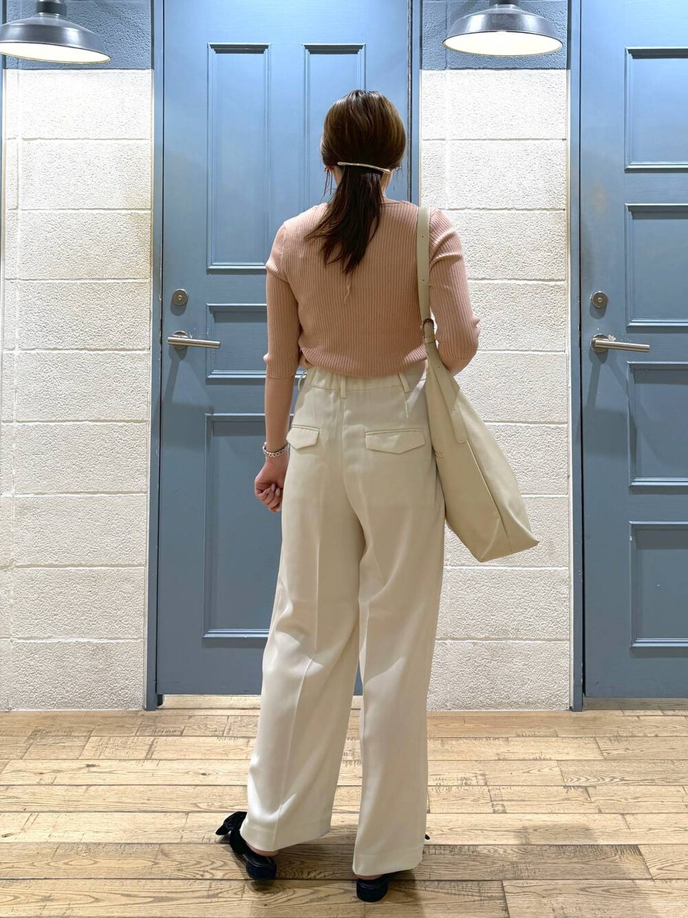 ブラック系のパンプス、ホワイト系のショルダーバッグ、ホワイト系のスラックスを着用したレディースの夏コーディネートの4枚目の写真