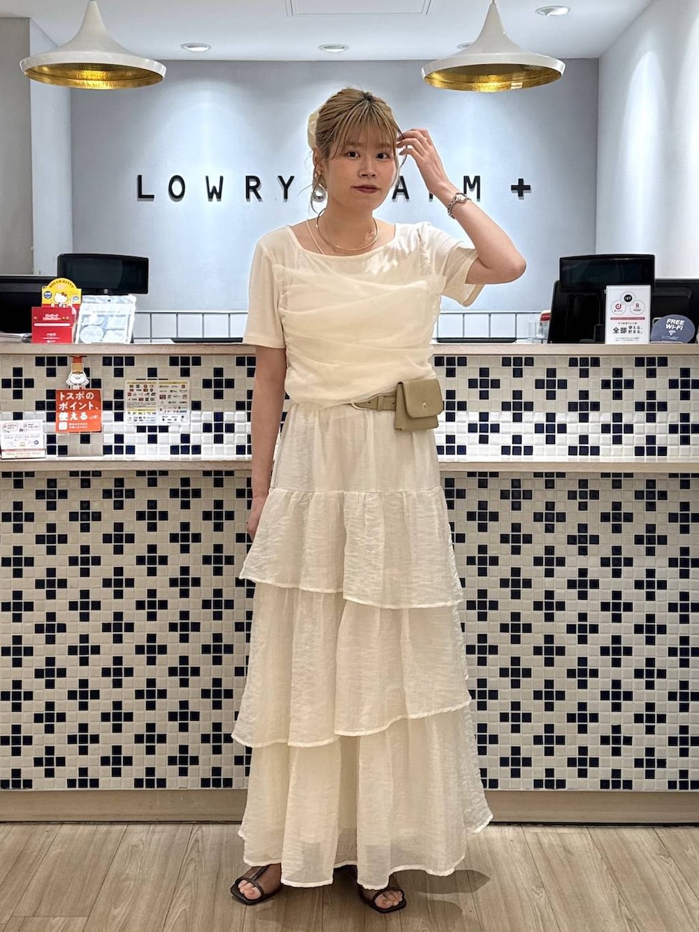 ホワイト系のTシャツ/カットソー、ブラウン系のサンダル、ホワイト系のスカートを着用したレディースの夏コーディネートの3枚目の写真