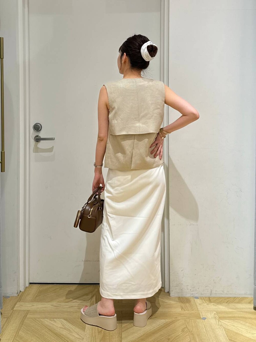 ホワイト系のサンダル、ベージュ系のブルゾン、ホワイト系のスカートを着用したレディースの夏コーディネートの4枚目の写真