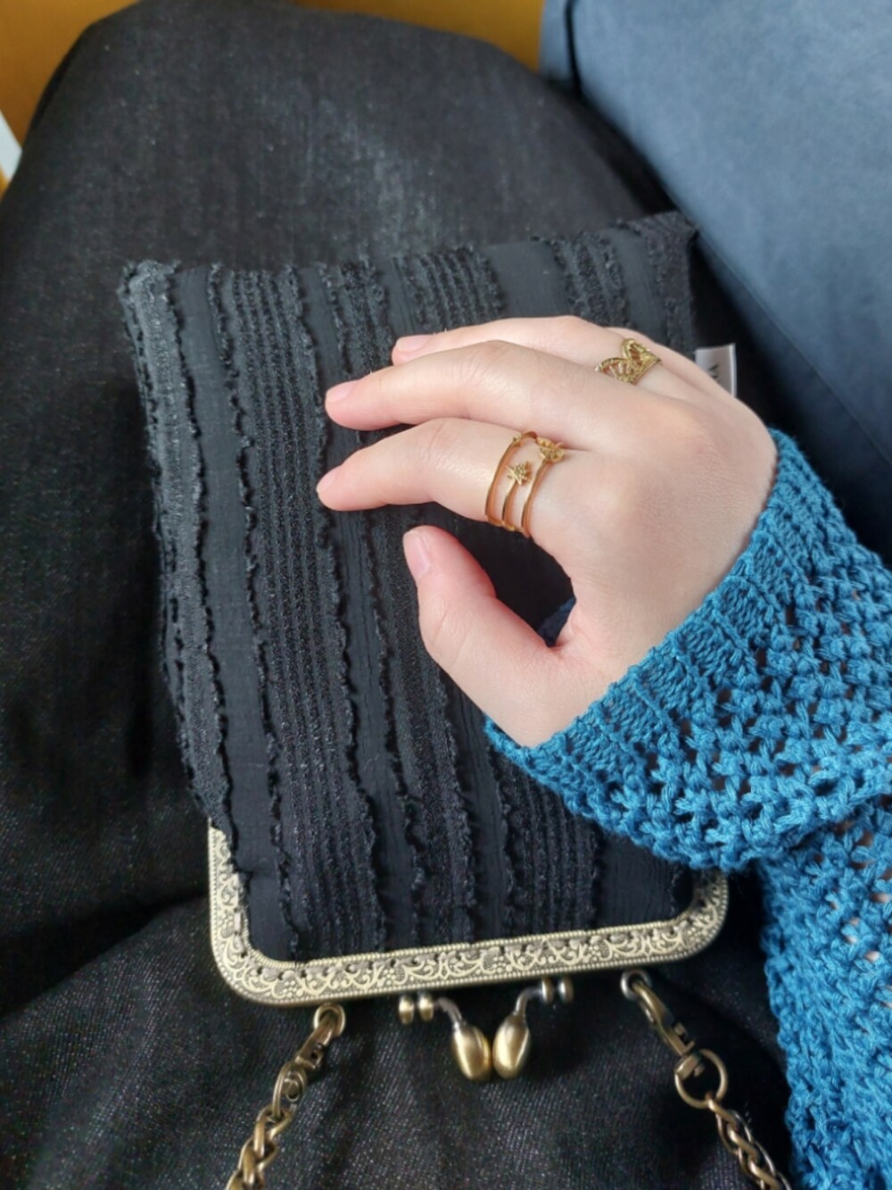 ブラック系のジャンパースカート、ブラック系のショルダーバッグ、ブルー系のニット/セーターを着用したレディースの秋コーディネートの3枚目の写真