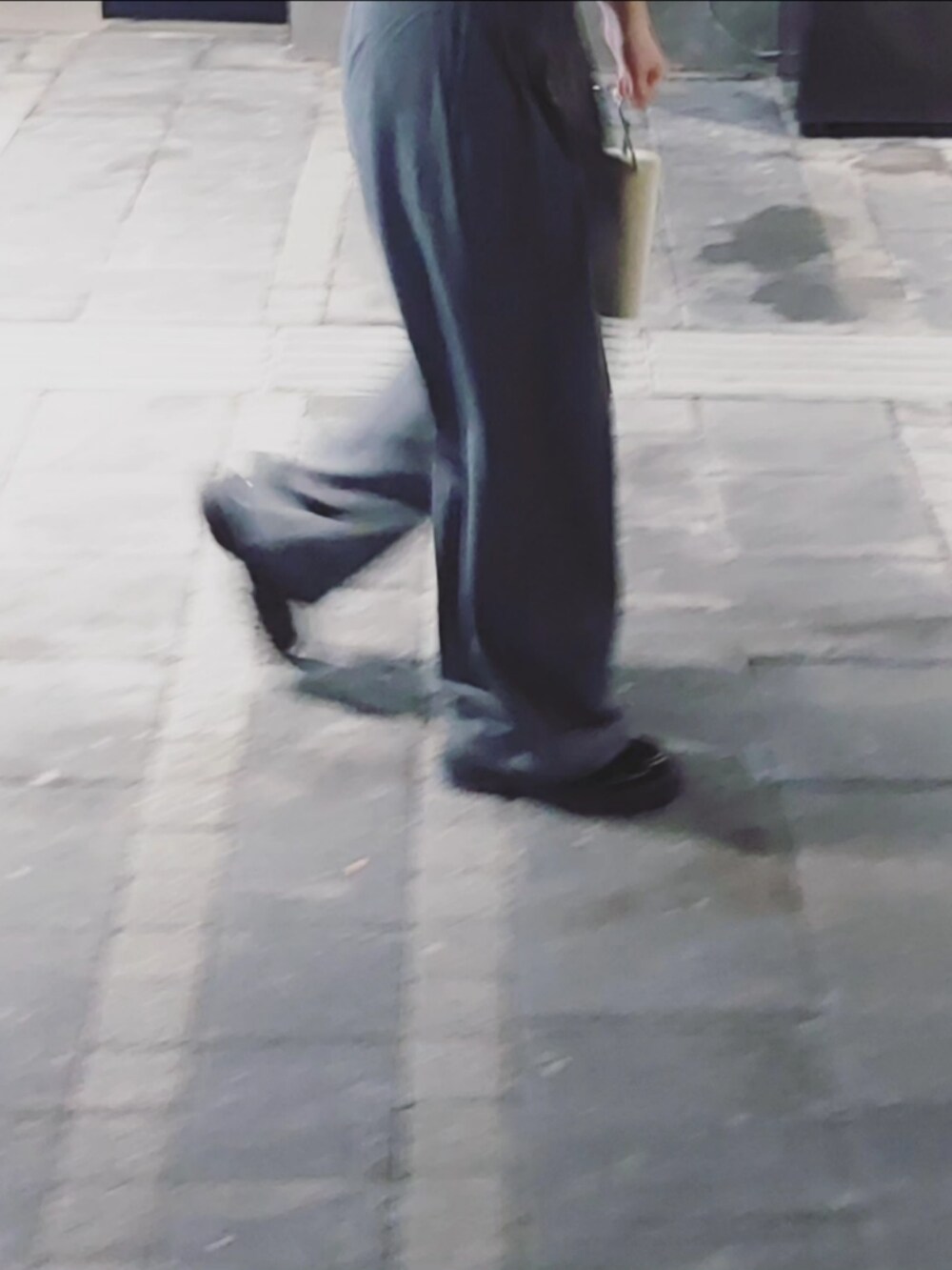 ブルー系のトップス、グレー系のスラックス、ブラック系のショルダーバッグを着用したレディースの秋コーディネートの2枚目の写真