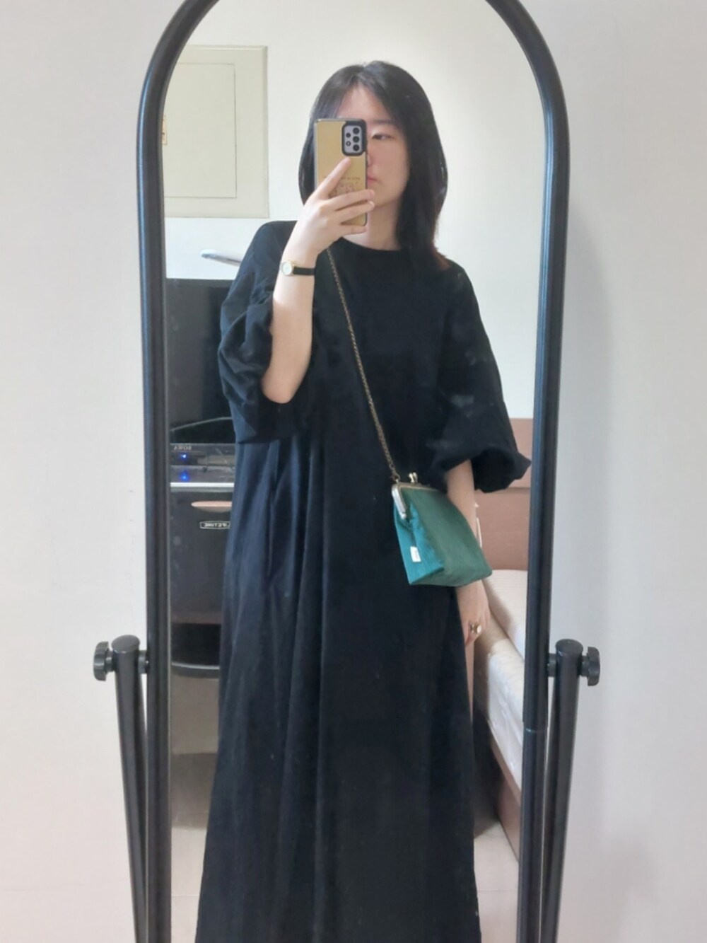 ブラック系のワンピース、グリーン系のトートバッグ、ブラック系のサンダルを着用したレディースの秋コーディネートの2枚目の写真