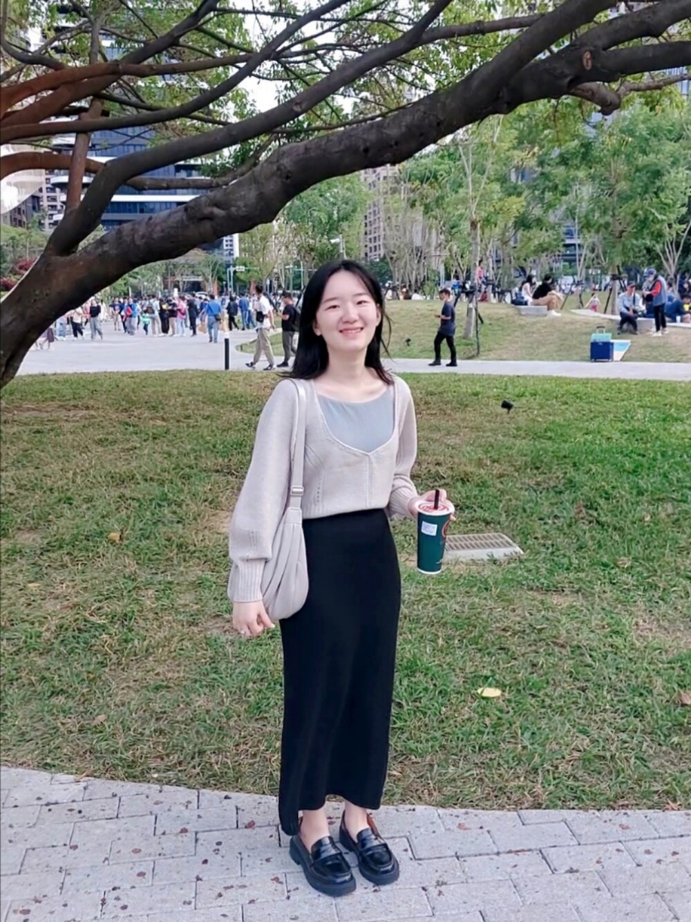 ベージュ系のニット/セーター、ブラック系のスカート、グレー系のチューブトップを着用したレディースの秋コーディネートの2枚目の写真