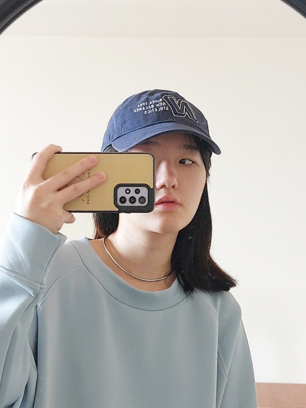 ブルー系のワンピース、シルバー系のネックレス、ブルー系のキャップを着用したレディースの秋コーディネートの2枚目の写真