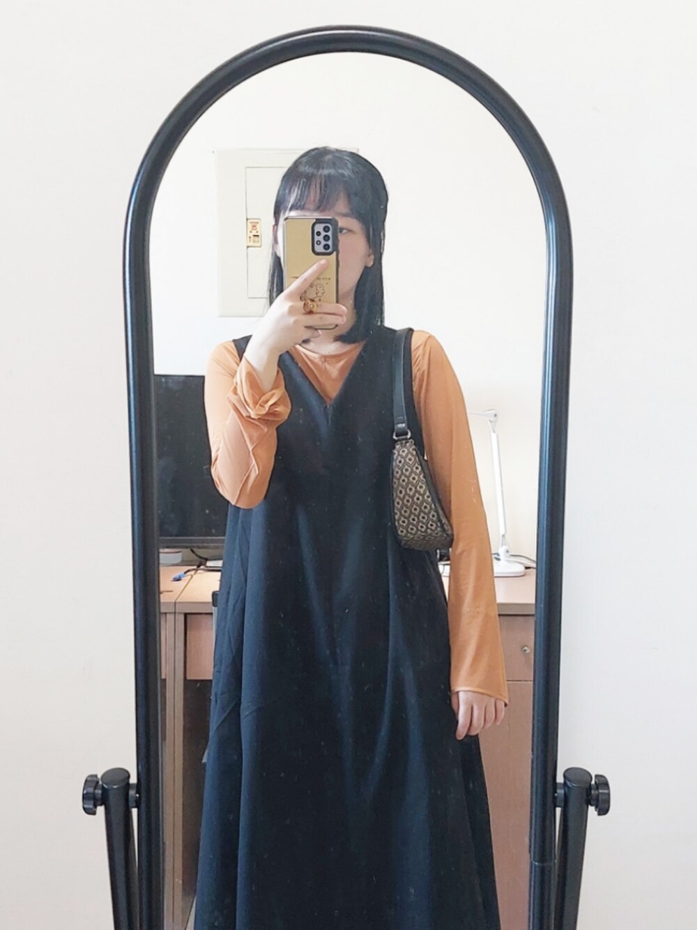 ブラック系のワンピース、オレンジ系のその他トップス、ブラック系のバレエシューズを着用したレディースの秋コーディネートの3枚目の写真