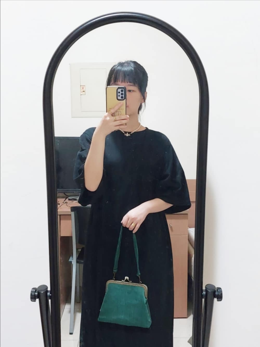 ブラック系のワンピース、ゴールド系のチョーカーを着用したレディースの夏コーディネートの2枚目の写真