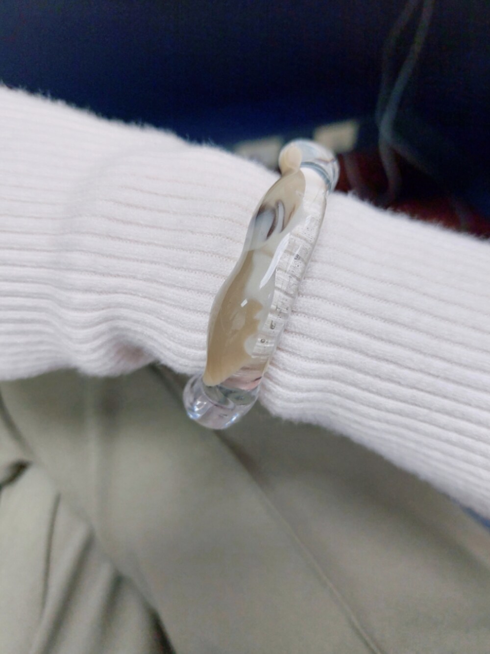 ベージュ系のベスト、ホワイト系のニット/セーター、グリーン系のスラックスを着用したレディースの冬コーディネートの2枚目の写真