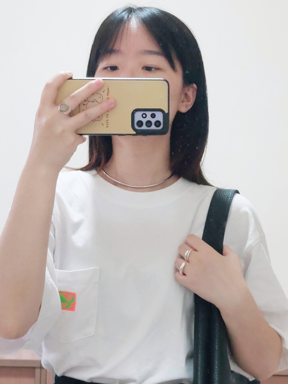 ホワイト系のTシャツ/カットソー、ブラック系のショルダーバッグ、ブルー系のキャップを着用したレディースの秋コーディネートの2枚目の写真