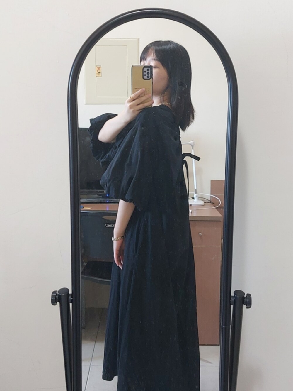 ブラック系のワンピース、ブラック系のローファー、ゴールド系のチョーカーを着用したレディースの秋コーディネートの2枚目の写真