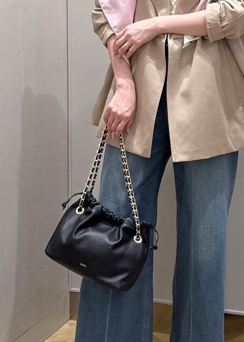 ブラック系のハンドバッグ、ホワイト系のニット/セーター、ブルー系のデニムパンツを着用したレディースの春コーディネートの10枚目の写真