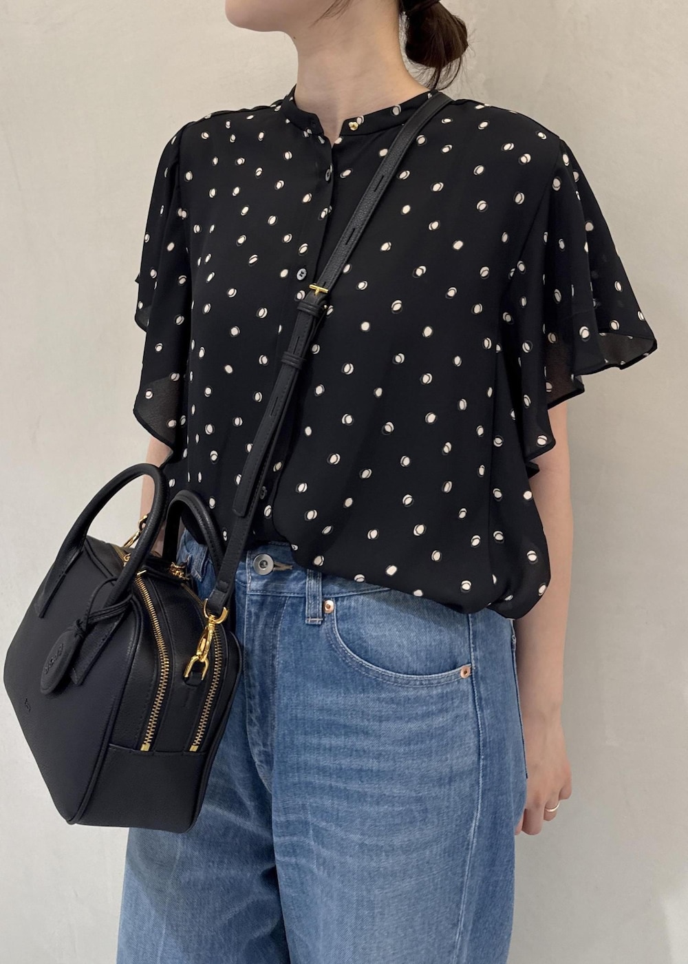 ブルー系のデニムパンツ、ブラック系のシャツ/ブラウス、ブラック系のハンドバッグを着用したレディースの夏コーディネートの4枚目の写真