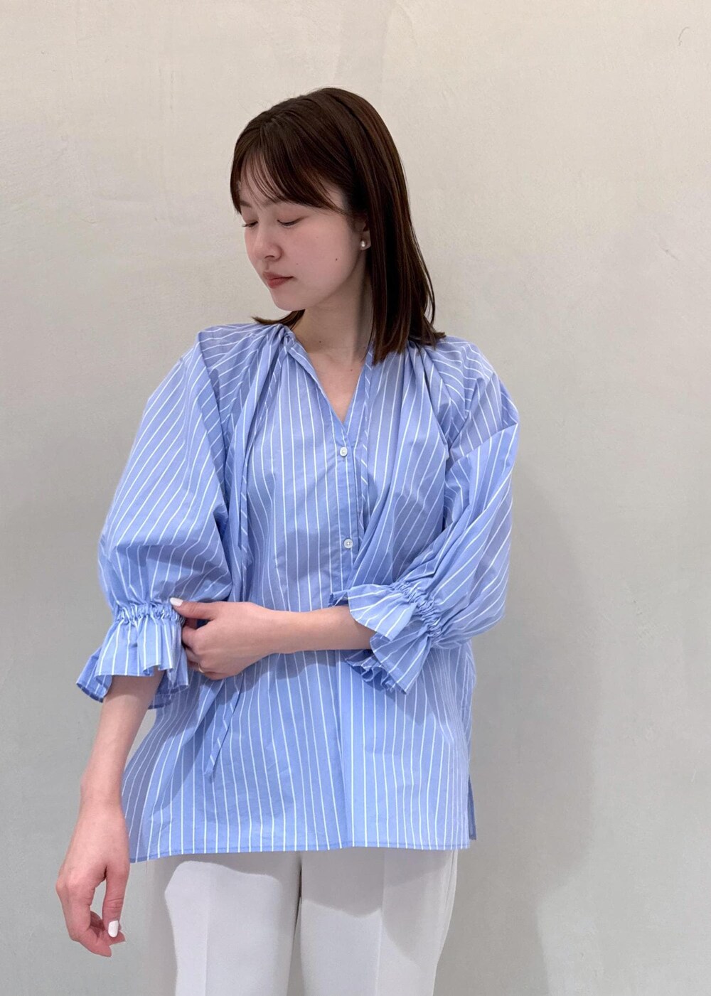 ベージュ系のその他パンツ、ブルー系のショルダーバッグ、ブルー系のシャツ/ブラウスを着用したレディースの春コーディネートの4枚目の写真