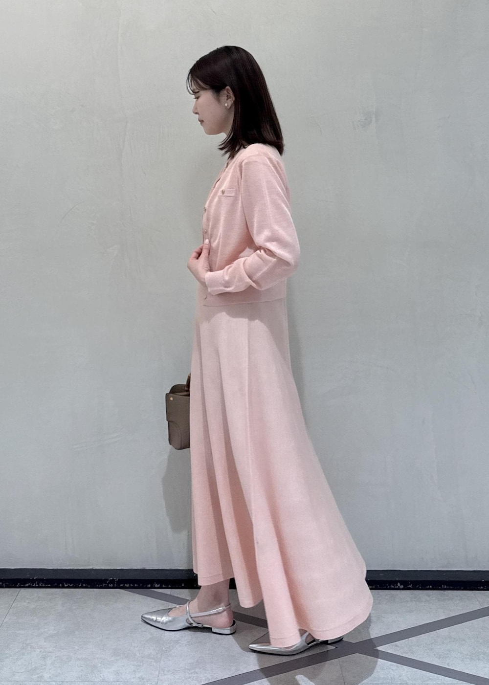 ベージュ系のハンドバッグを着用したレディースの春コーディネートの3枚目の写真