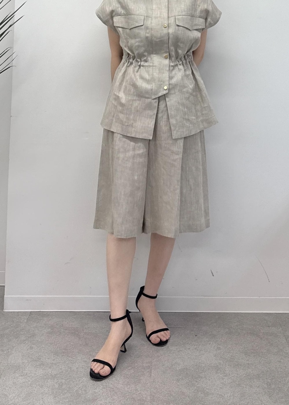 ベージュ系のベスト、ベージュ系のその他パンツ、ブラック系のハンドバッグを着用したレディースの夏コーディネートの6枚目の写真