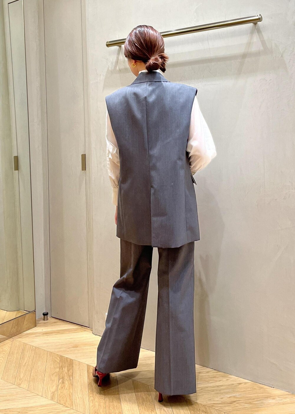 レッド系のパンプス、グレー系のベスト、グレー系のその他パンツを着用したレディースの秋コーディネートの3枚目の写真