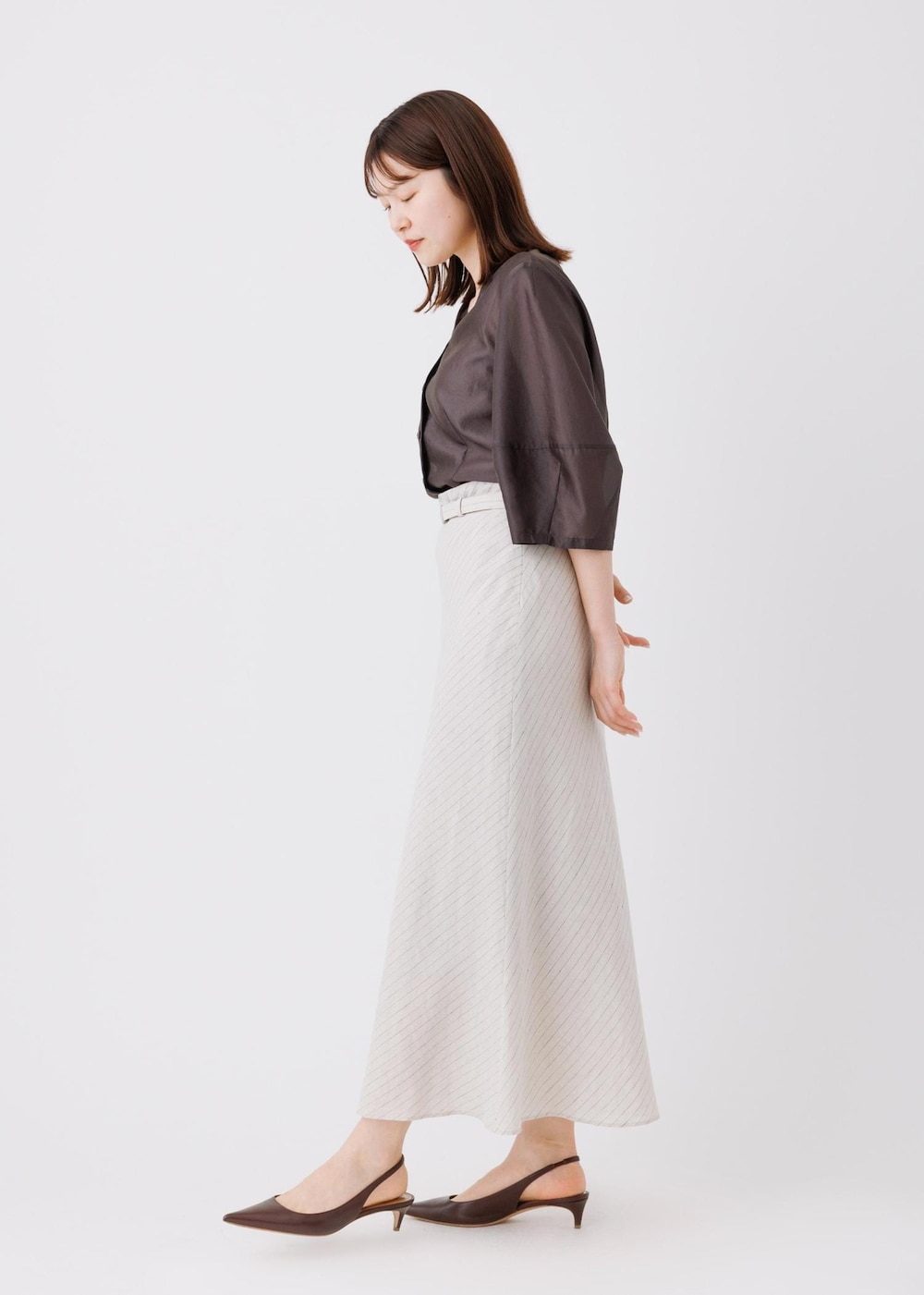 ベージュ系のスカート、ブラック系のシャツ/ブラウスを着用したレディースの春コーディネートの3枚目の写真