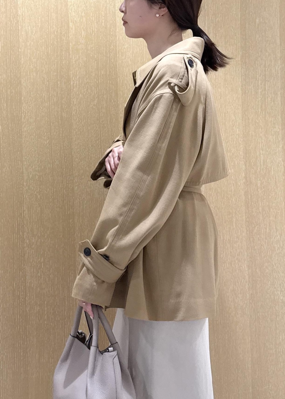 ベージュ系のトレンチコート、ベージュ系のスカート、ピンク系のシャツ/ブラウスを着用したレディースの春コーディネートの6枚目の写真