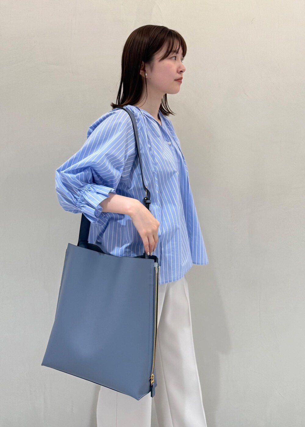 ベージュ系のその他パンツ、ブルー系のショルダーバッグ、ブルー系のシャツ/ブラウスを着用したレディースの春コーディネートの7枚目の写真