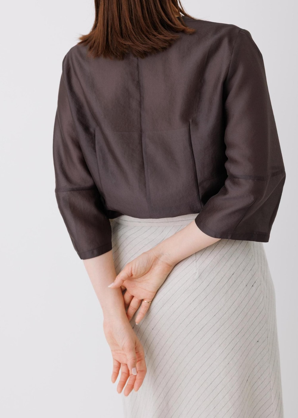 ベージュ系のスカート、ブラック系のシャツ/ブラウスを着用したレディースの春コーディネートの5枚目の写真