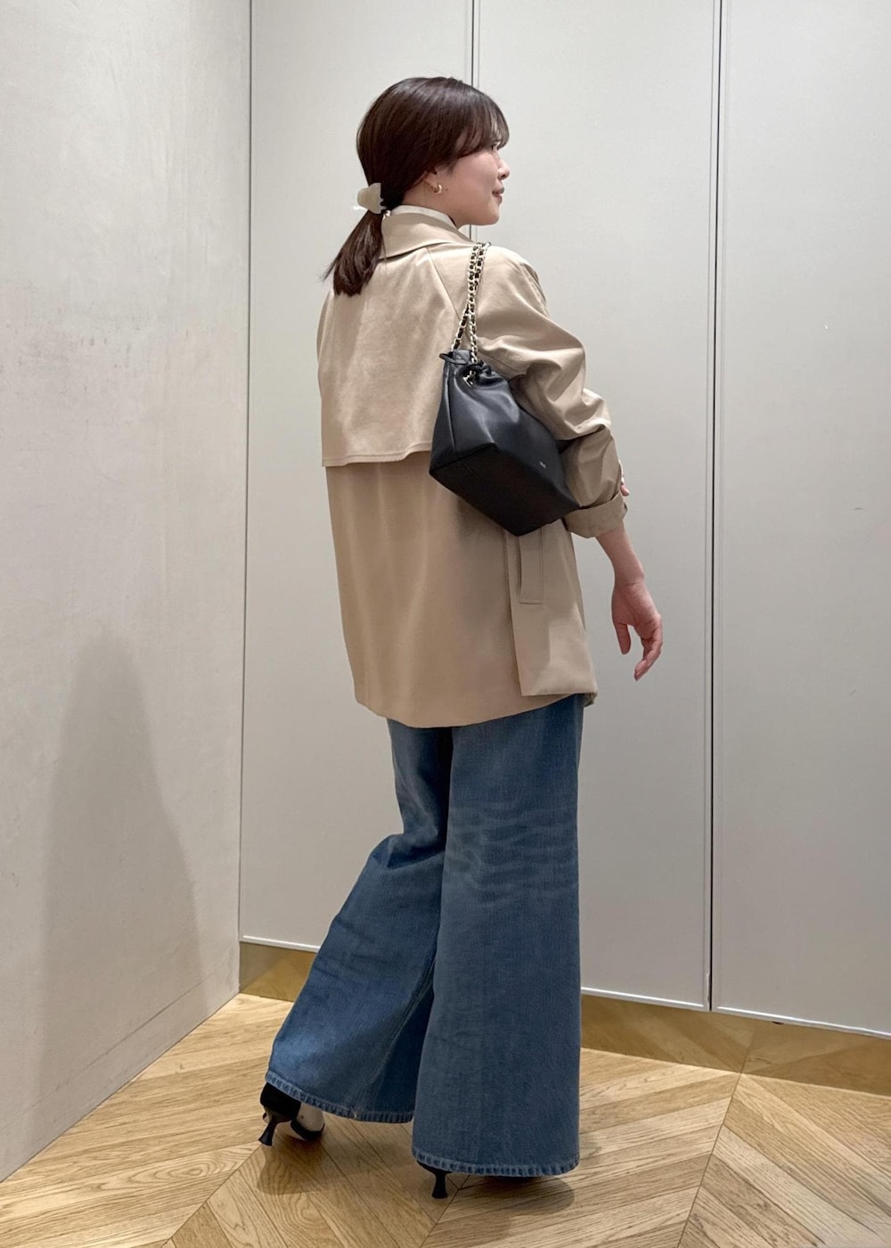 ブラック系のハンドバッグ、ホワイト系のニット/セーター、ブルー系のデニムパンツを着用したレディースの春コーディネートの4枚目の写真