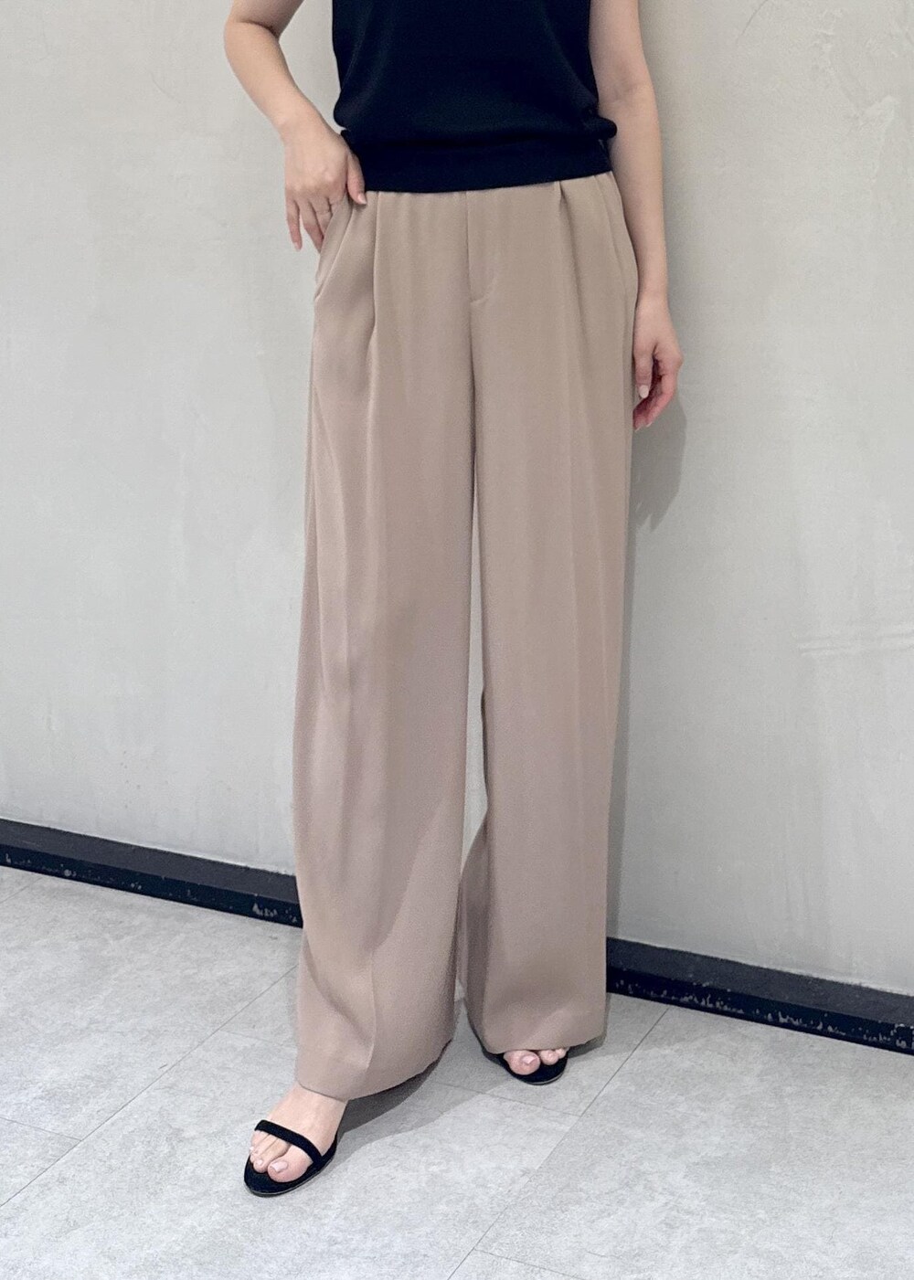 ベージュ系のトートバッグ、ベージュ系のその他パンツ、ブラック系のTシャツ/カットソーを着用したレディースの春コーディネートの9枚目の写真