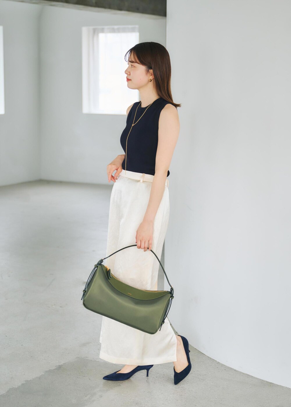 ブルー系のニット/セーター、グリーン系のハンドバッグ、ホワイト系のスカートを着用したレディースの春コーディネートの2枚目の写真