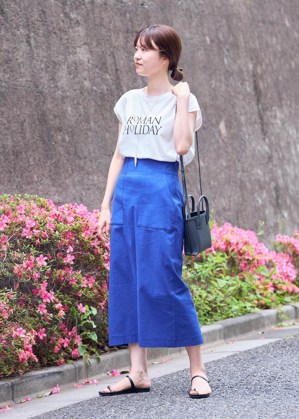 グレー系のショルダーバッグ、ブラック系のサンダル、ブルー系のスカートを着用したレディースの夏コーディネートの2枚目の写真