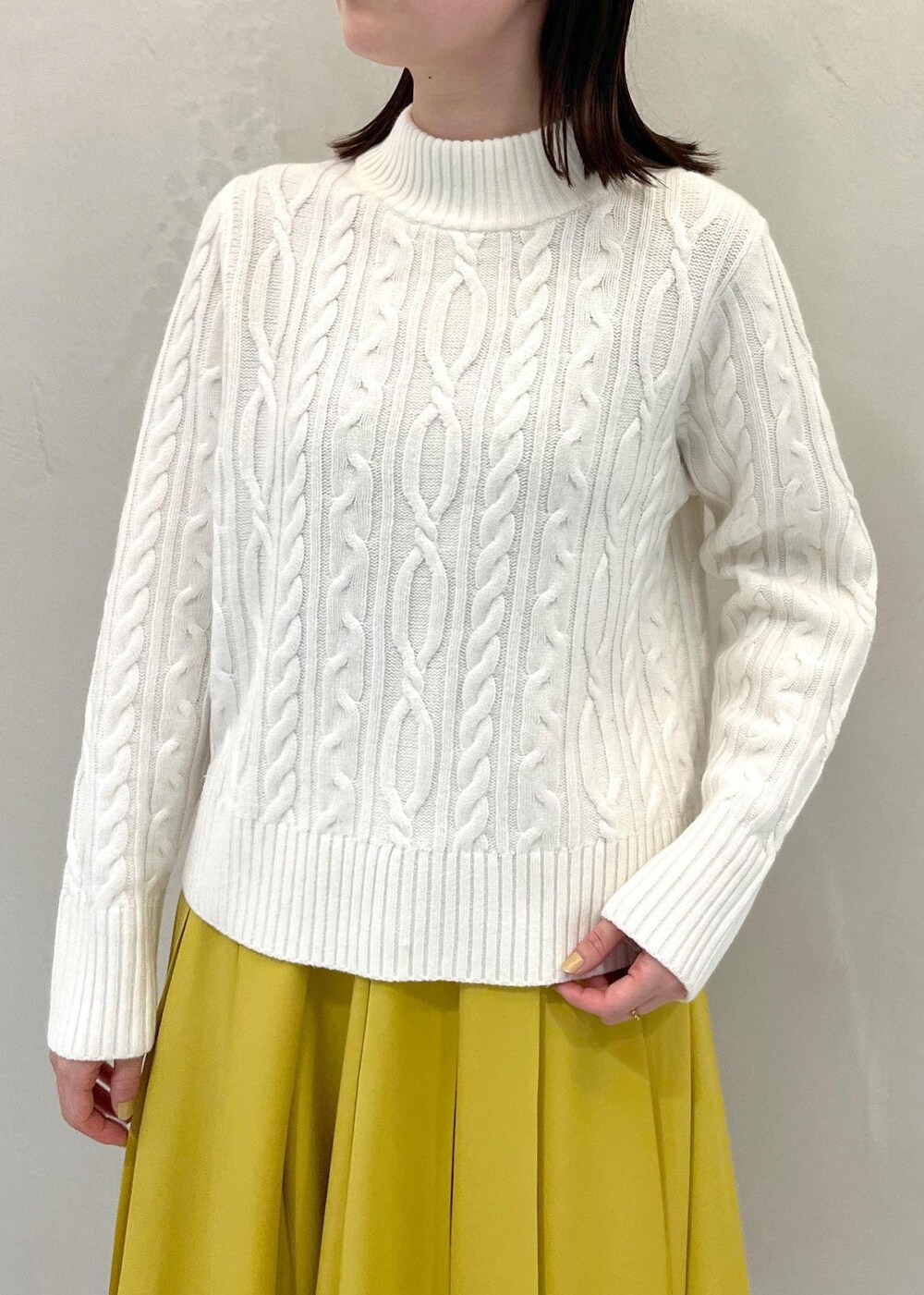 ブラウン系のブーツ、イエロー系のスカート、ブラック系のバックパック/リュックを着用したレディースの冬コーディネートの4枚目の写真