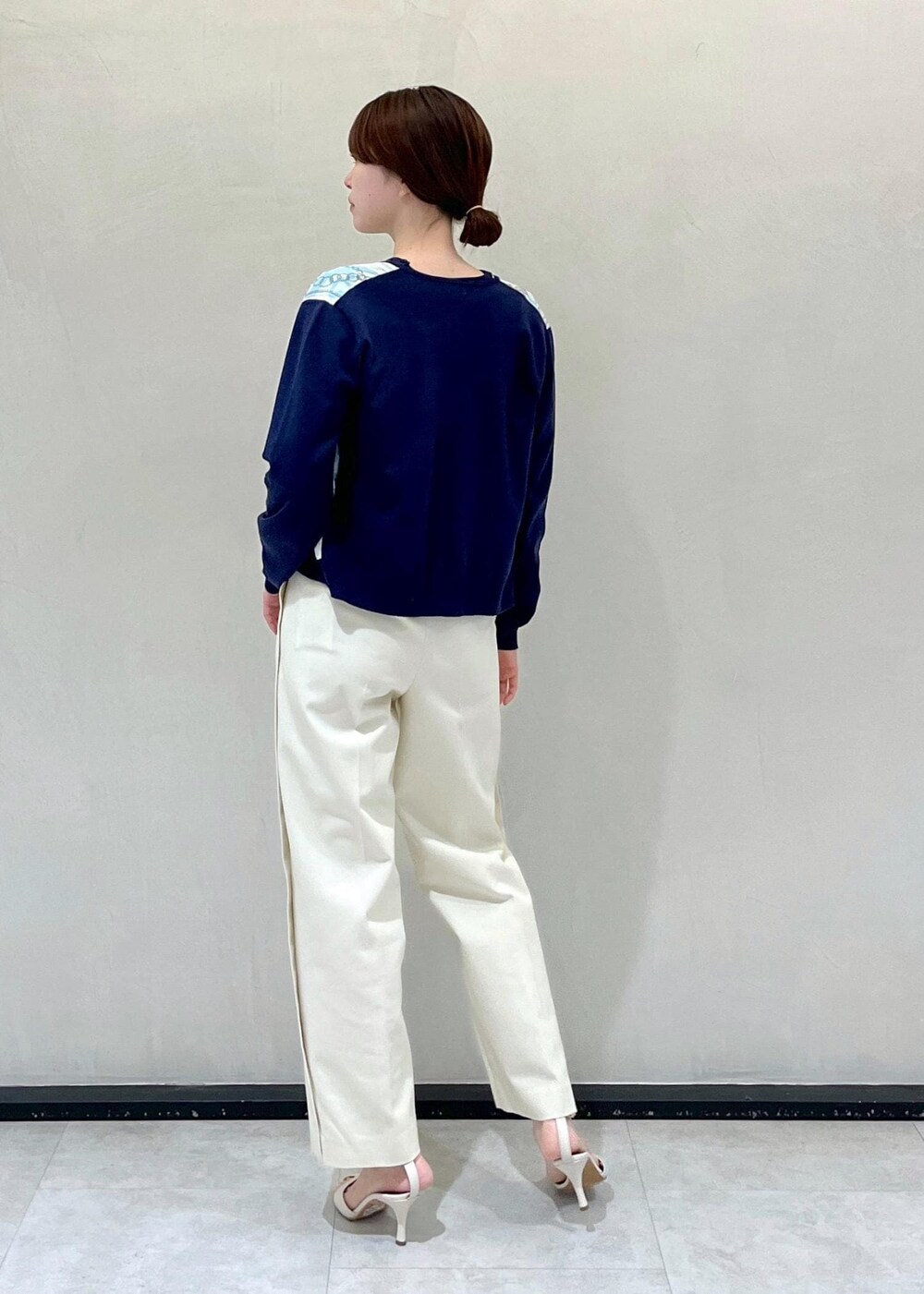 ホワイト系のハンドバッグ、ホワイト系のその他パンツ、ブルー系のニット/セーターを着用したレディースの春コーディネートの3枚目の写真