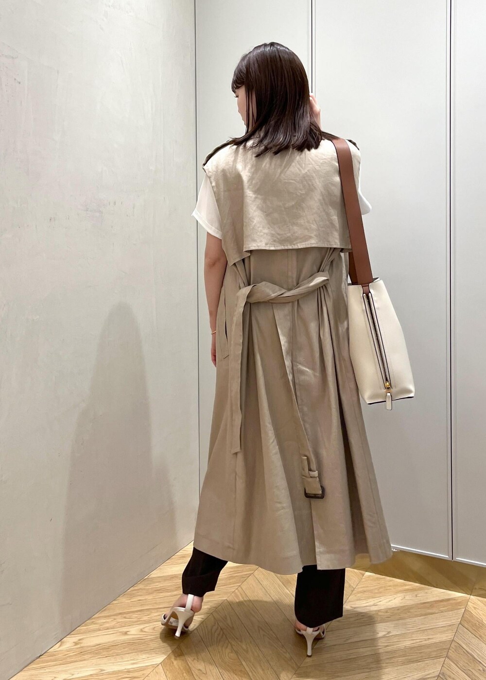 ホワイト系のサンダル、ベージュ系のベスト、ホワイト系のTシャツ/カットソーを着用したレディースの春コーディネートの3枚目の写真