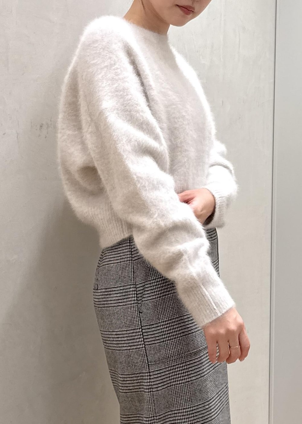 ブラウン系のブーツ、ブラウン系のハンドバッグ、ホワイト系のステンカラーコートを着用したレディースの秋コーディネートの5枚目の写真