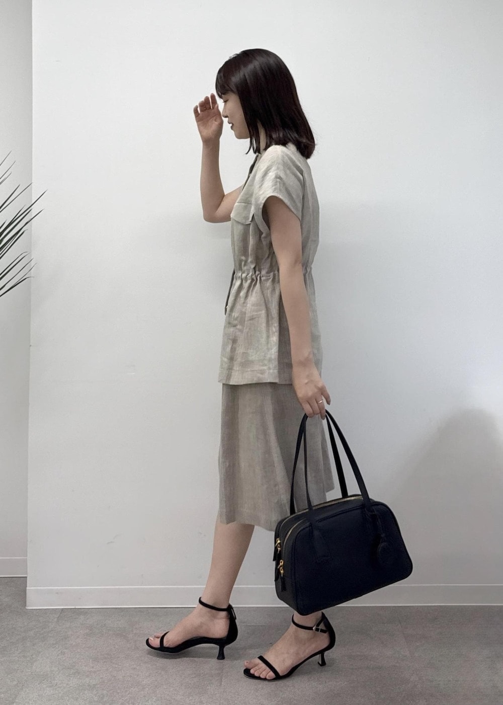 ベージュ系のベスト、ベージュ系のその他パンツ、ブラック系のハンドバッグを着用したレディースの夏コーディネートの2枚目の写真
