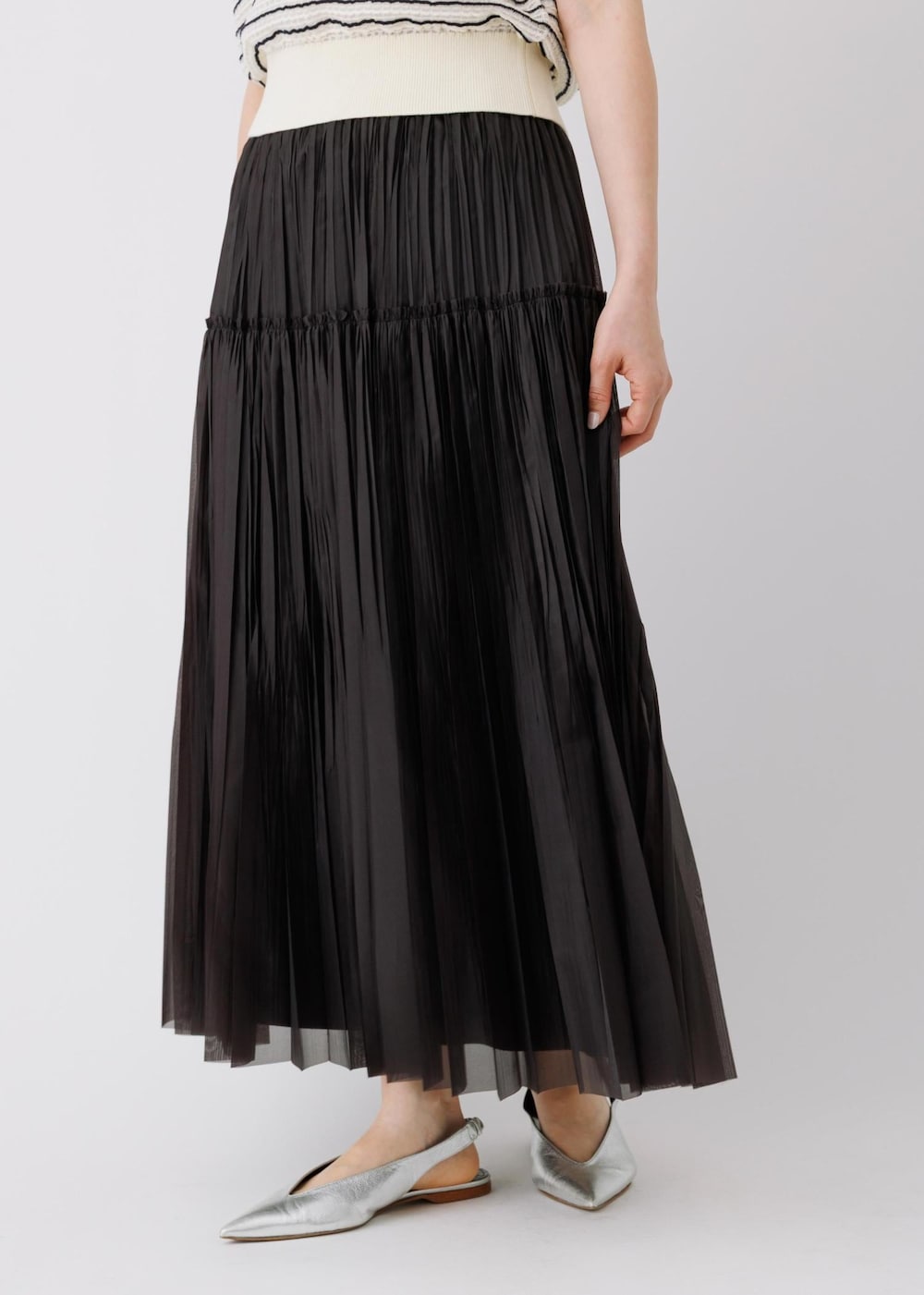 ブラック系のスカート、ホワイト系のニット/セーター、グレー系のトートバッグを着用したレディースの春コーディネートの6枚目の写真