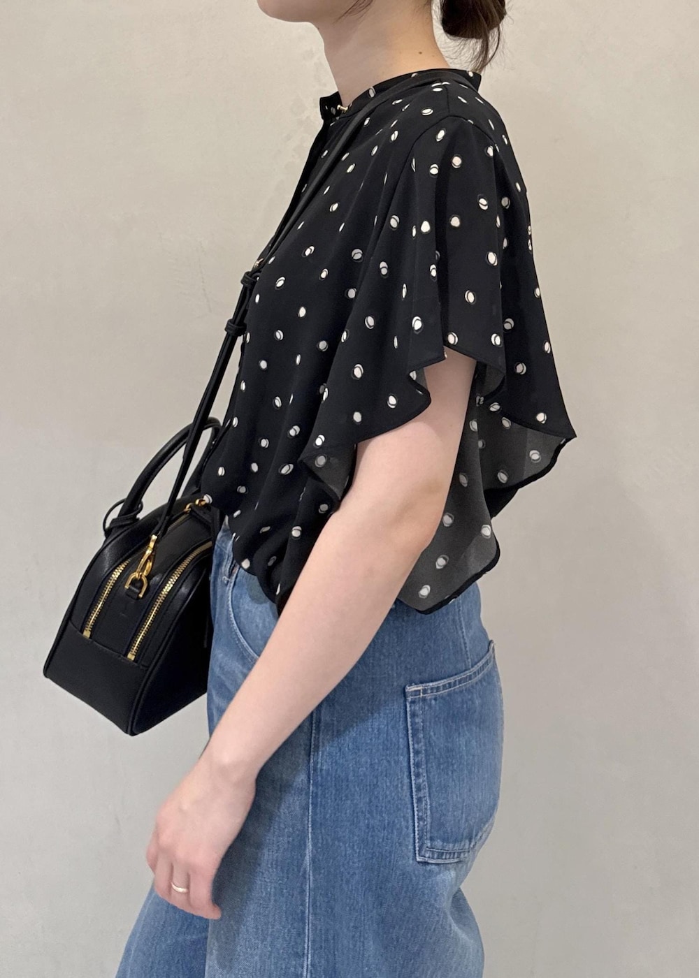 ブルー系のデニムパンツ、ブラック系のシャツ/ブラウス、ブラック系のハンドバッグを着用したレディースの夏コーディネートの5枚目の写真