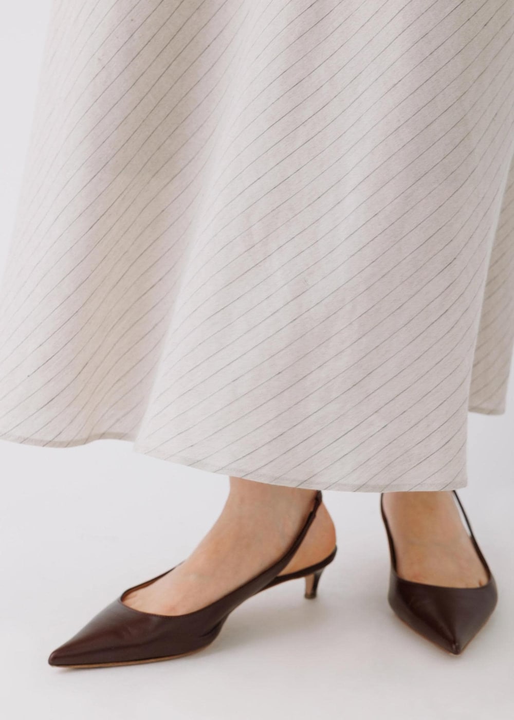 ベージュ系のスカート、ブラック系のシャツ/ブラウスを着用したレディースの春コーディネートの7枚目の写真