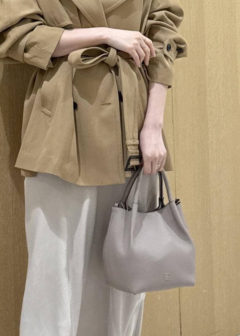 ベージュ系のトレンチコート、ベージュ系のスカート、ピンク系のシャツ/ブラウスを着用したレディースの春コーディネートの10枚目の写真