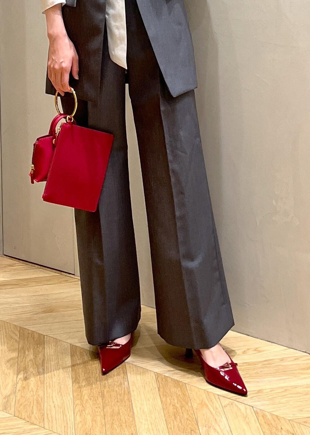 レッド系のパンプス、グレー系のベスト、グレー系のその他パンツを着用したレディースの秋コーディネートの9枚目の写真