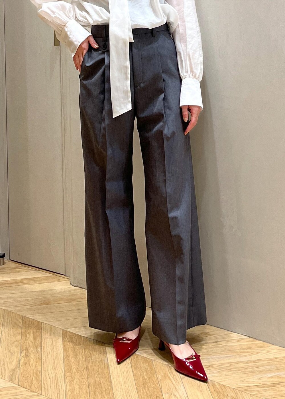 レッド系のパンプス、グレー系のベスト、グレー系のその他パンツを着用したレディースの秋コーディネートの7枚目の写真