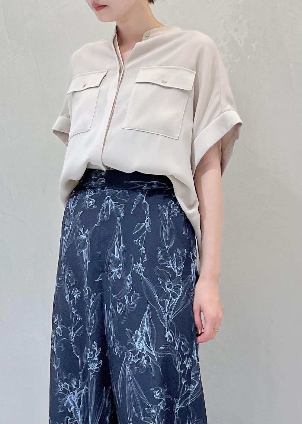 ブラック系のハンドバッグ、ベージュ系のサンダル、ベージュ系のシャツ/ブラウスを着用したレディースの夏コーディネートの5枚目の写真